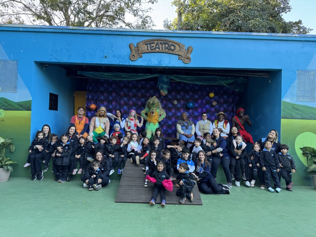 Crianças da Educação Infantil e 1º ano do Colégio Dom Bosco interagindo com personagens do Mundo de Monteiro Lobato, participando de atividades lúdicas e explorando o ambiente natural do Refúgio Kids.