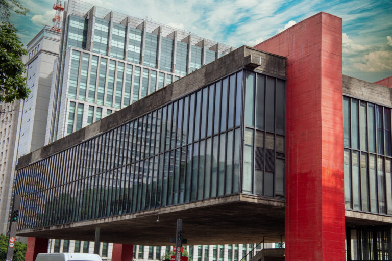 Fachada do MASP — Museu de Arte de São Paulo — com sua estrutura icônica de concreto e pilares vermelhos, localizada na Avenida Paulista, em São Paulo.