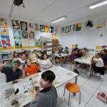 Alunos do 4º ano do Colégio Dom Bosco construindo maquete de aldeia indígena com argila.