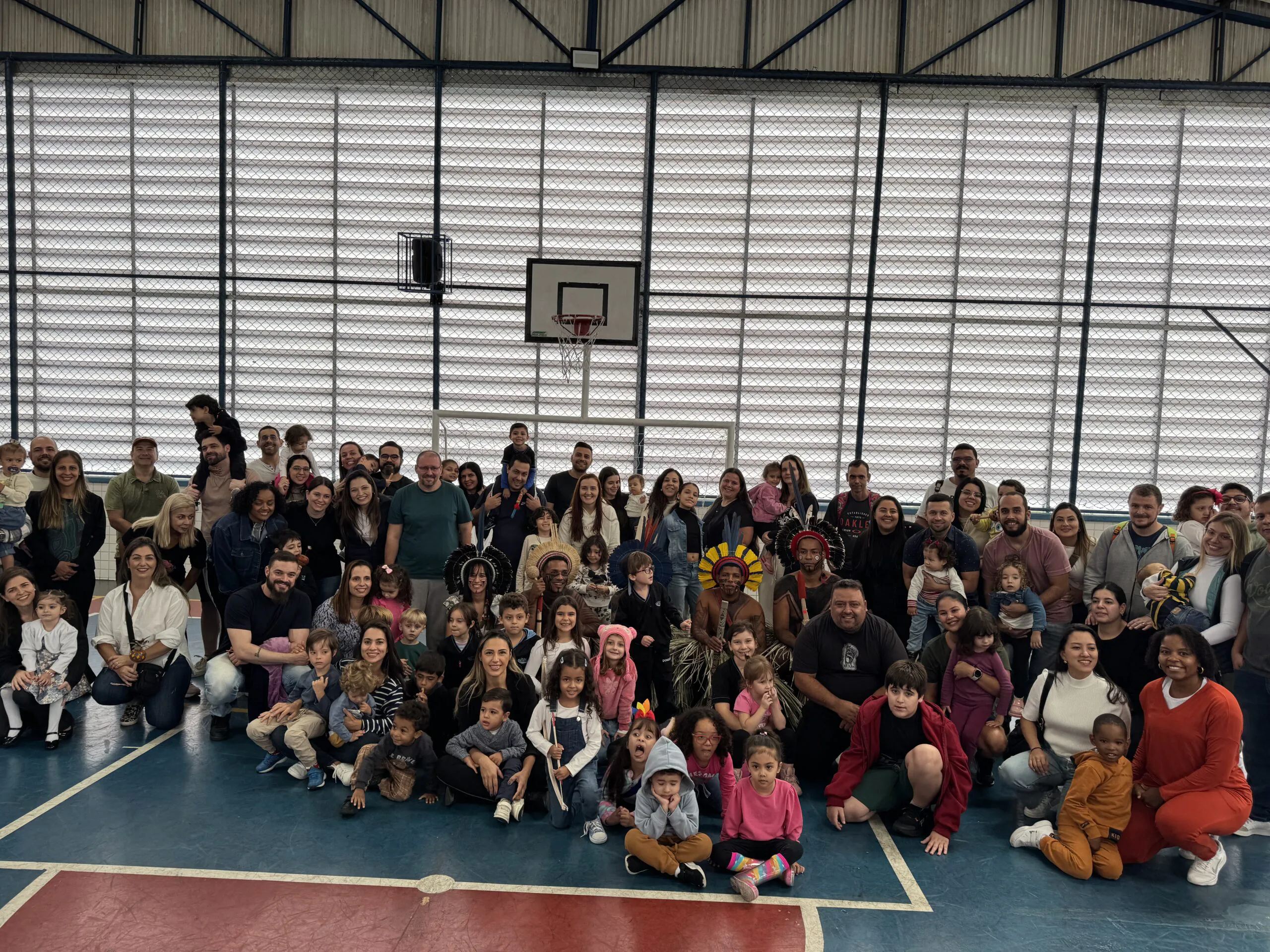Famílias e alunos reunidos em quadra esportiva com a Tribo Indígena Kariri-Xocó