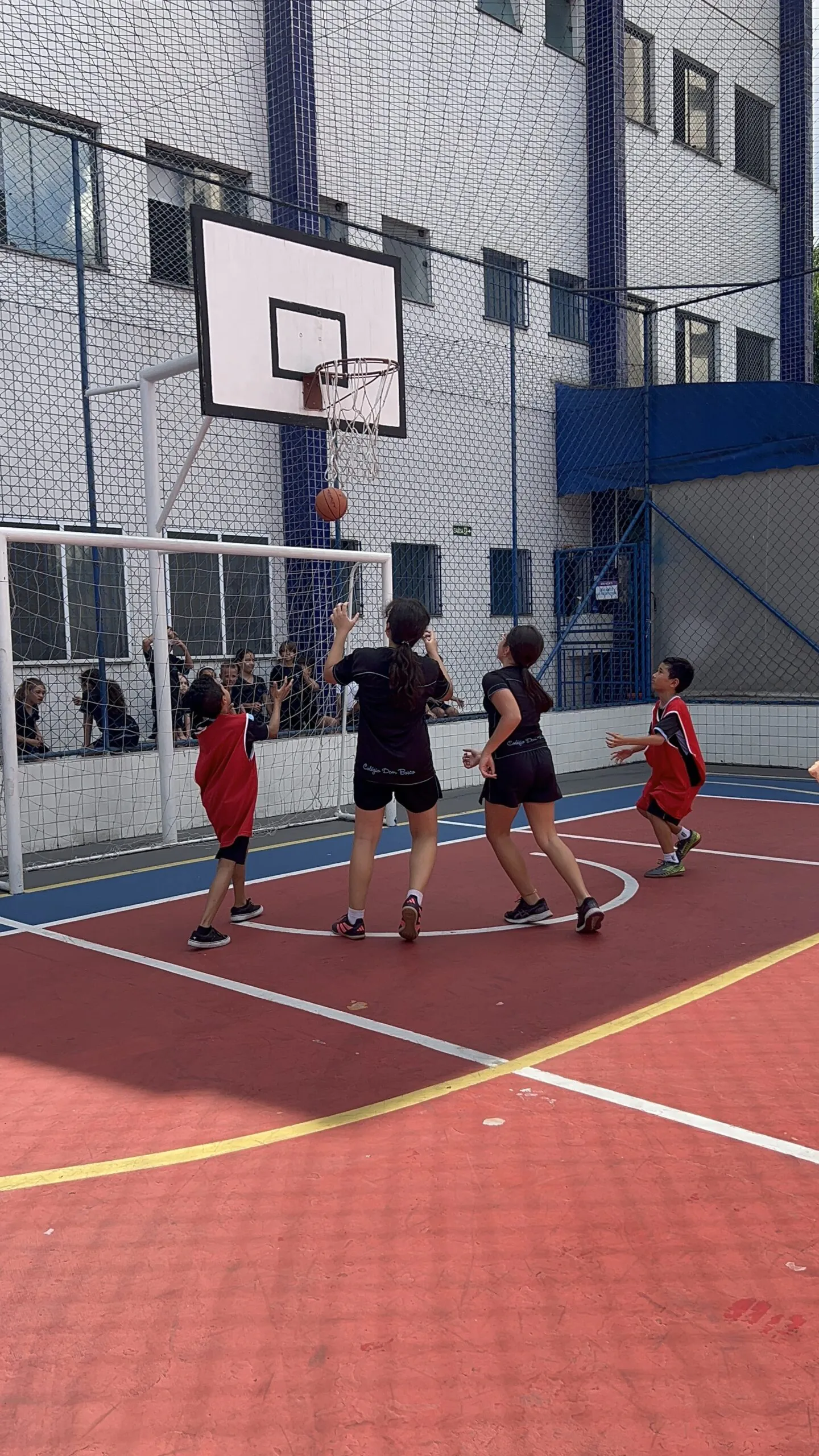 Alunos do Colégio Dom Bosco durante aula ao ar livre de basquete.